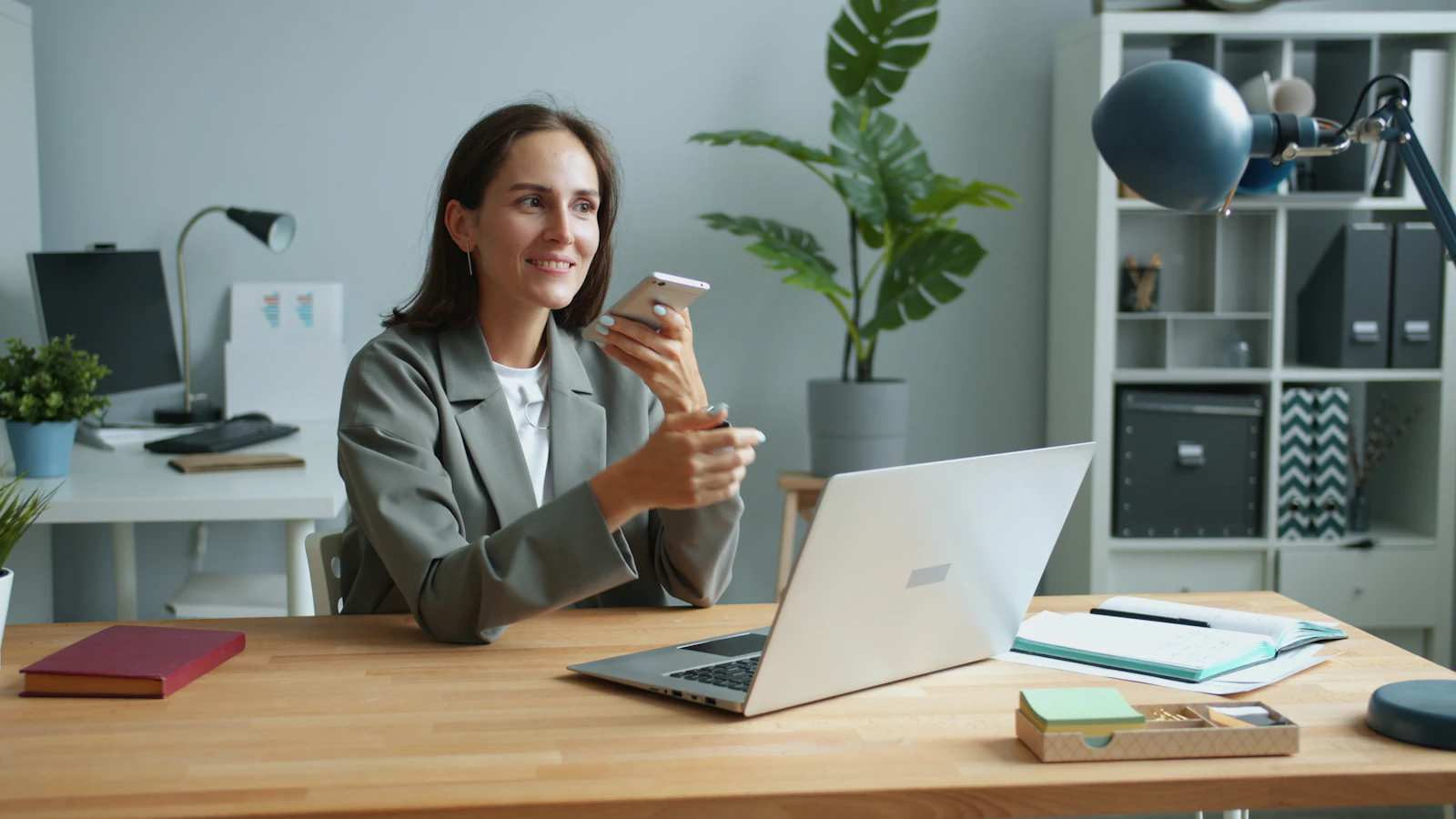 Agente immobiliare al telefono con un cliente, alla scrivania dell'agenzia